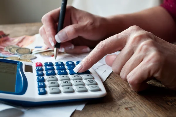 Close-up of a woman using a calculator for household finances
